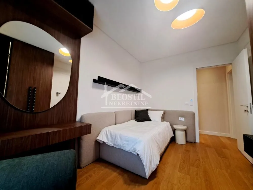 Small bedroom with a sofa bed and a wall mirror.