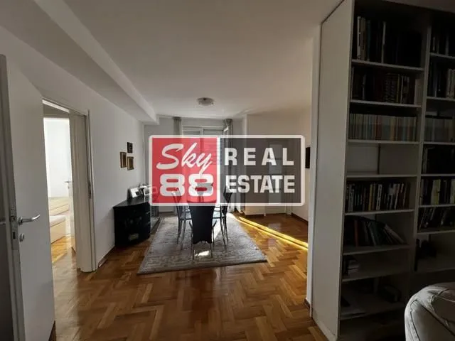 Dnevna soba sa trpezarijom i policom za knjige.