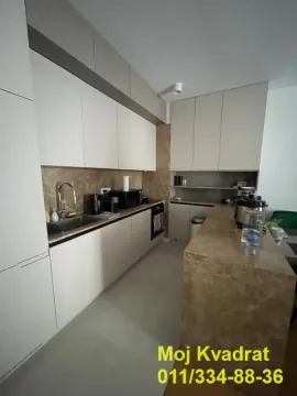 Modern kitchen with built-in cabinetry and a breakfast bar. - image 10