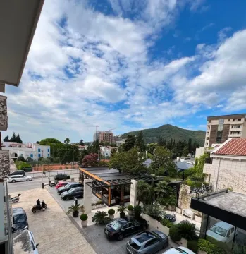 Pogled sa terase na grad, okolne zgrade i planine. - image 5
