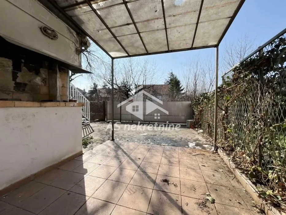 Natkriveni popločani deo dvorišta sa roštiljem.