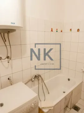 Manje kupatilo sa bijelim pločicama, kadom, bojlerom i mašinom za veš. - image 2