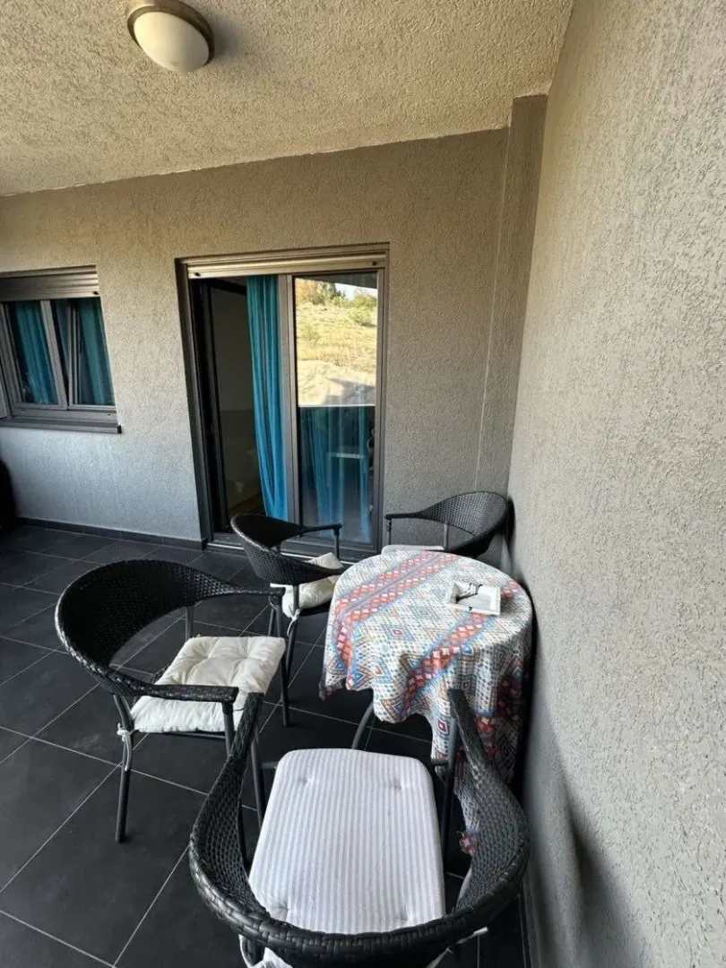 Covered terrace with seating set and table.