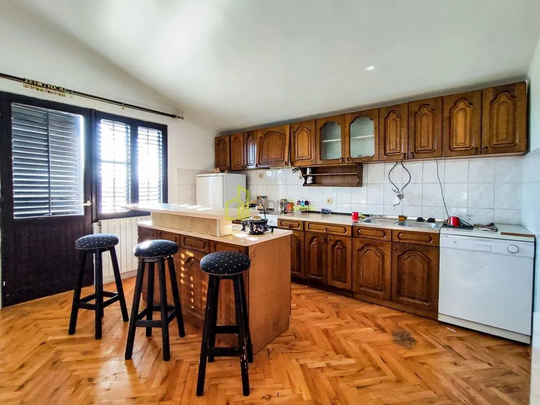 Kitchen with wooden cabinetry, a breakfast bar, and bar stools.