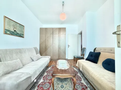 Living room furnished with seating sets, wooden closets, and a rug. - image 8