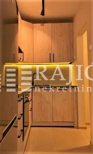 Modern kitchen with wooden cabinets and built-in lighting.