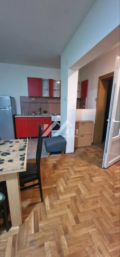 Kuhinja sa crvenim elementima i trpezarijom u nastavku.