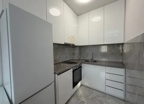 Moderna bijela kuhinja sa ugrađenim elementima i frižiderom. - image 11