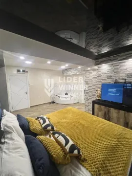 Spavaća soba sa bračnim krevetom, televizorom i đakuzijem u pozadini. - image 7