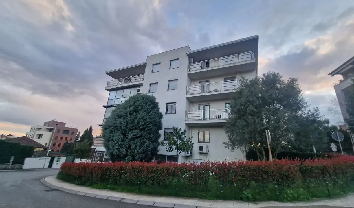 Exterior of a multi-story residential building with greenery.