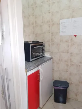 Manja kuhinja sa mini pećnicom, frižiderom i pločicama na zidu. - image 4