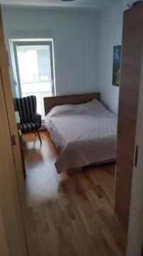 Svijetla spavaća soba sa bračnim krevetom i prugastom foteljom. - image 7