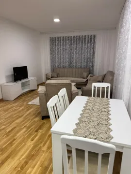 Living room with a sofa set, TV unit, and dining table. - image 10