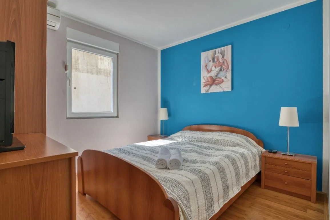 Furnished bedroom with a double bed and a blue wall.