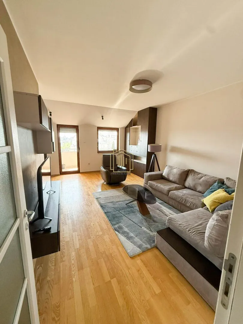 Living room with sofa, TV unit and access to the terrace.
