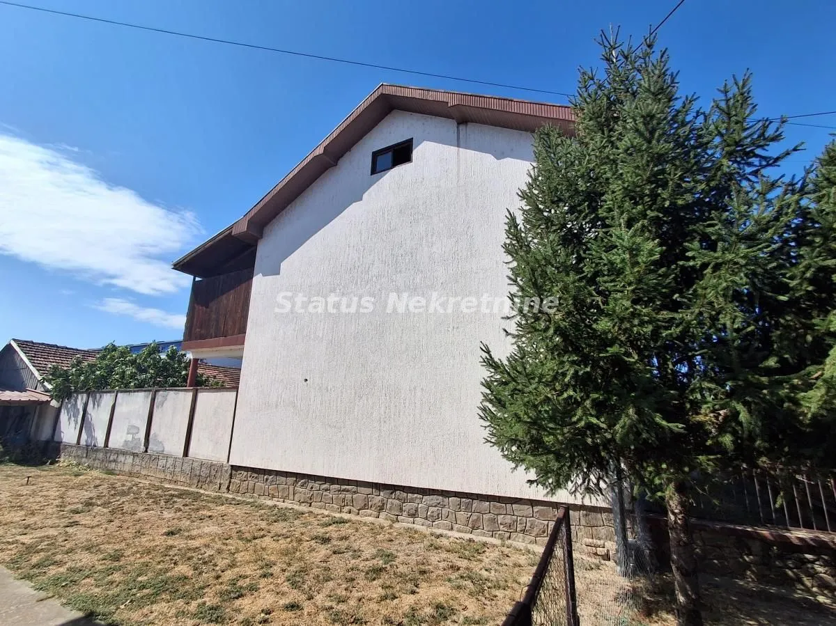Pogled na spoljašnjost kuće sa dvorištem i zelenilom.