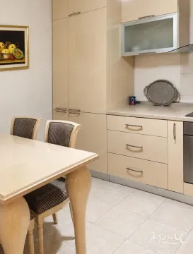 Part of the kitchen with beige cabinets and a dining table. - image 4