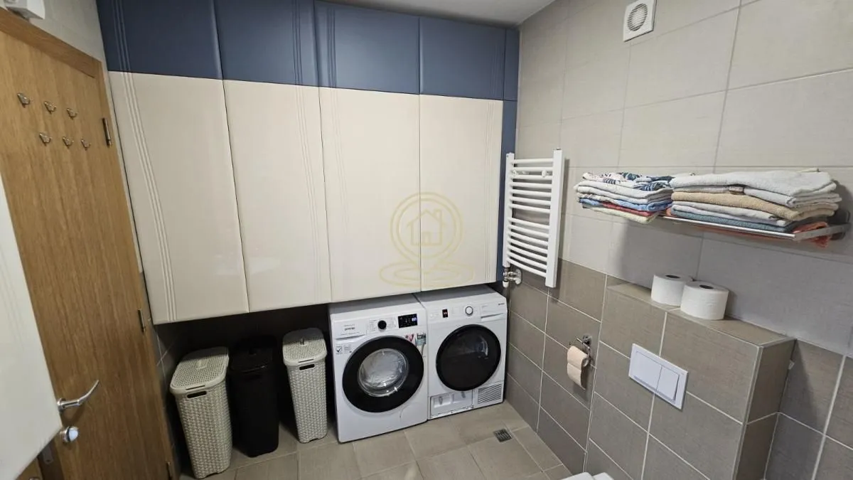 Bathroom with washing machine, tumble dryer and built-in cabinets.