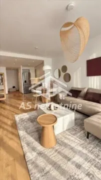 Living room with a sofa, coffee table, and a view of the dining area and kitchen. - image 3