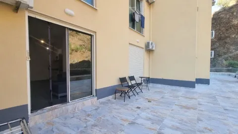 Terasa sa popločanim podom i garniturom za sedenje ispred ulaza u stan. - image 7