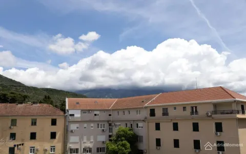 Pogled sa prozora na okolne zgrade i planine u pozadini. - image 12