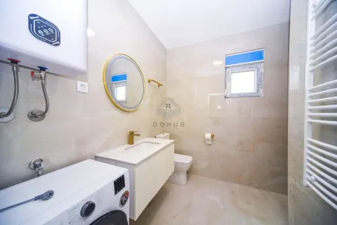 Modernly equipped bathroom with a washbasin, toilet, washing machine, and water heater. - image 8