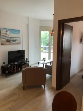 Living room with furniture, television, and balcony access. - image 2