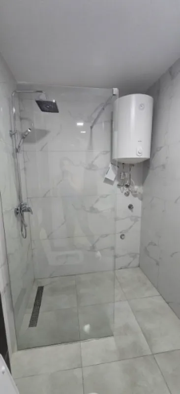 Moderne kupatilo sa tuš kabinom i bojlerom.