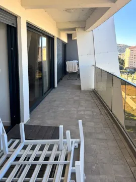 Prostrani popločani balkon sa staklenom ogradom i pogledom na okolinu. - image 8