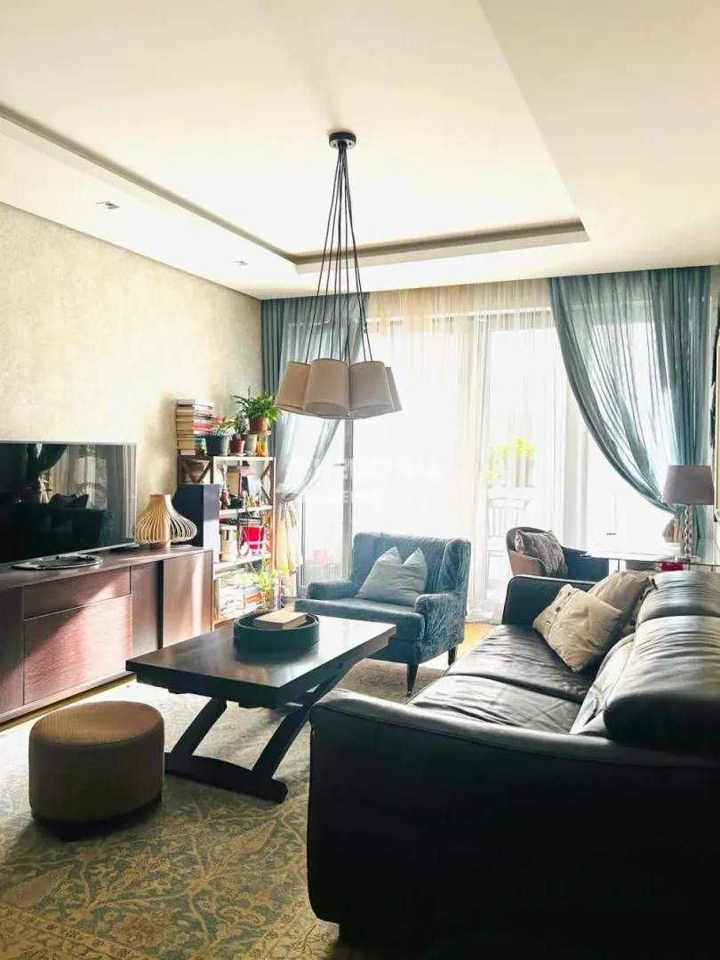 Living room with a sofa set, TV, and access to the terrace.