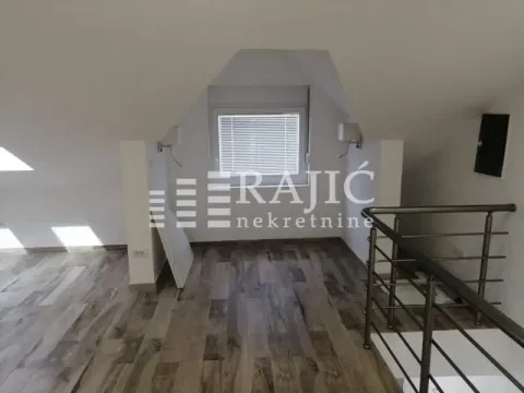 Attic space with laminate flooring and a window. - image 4