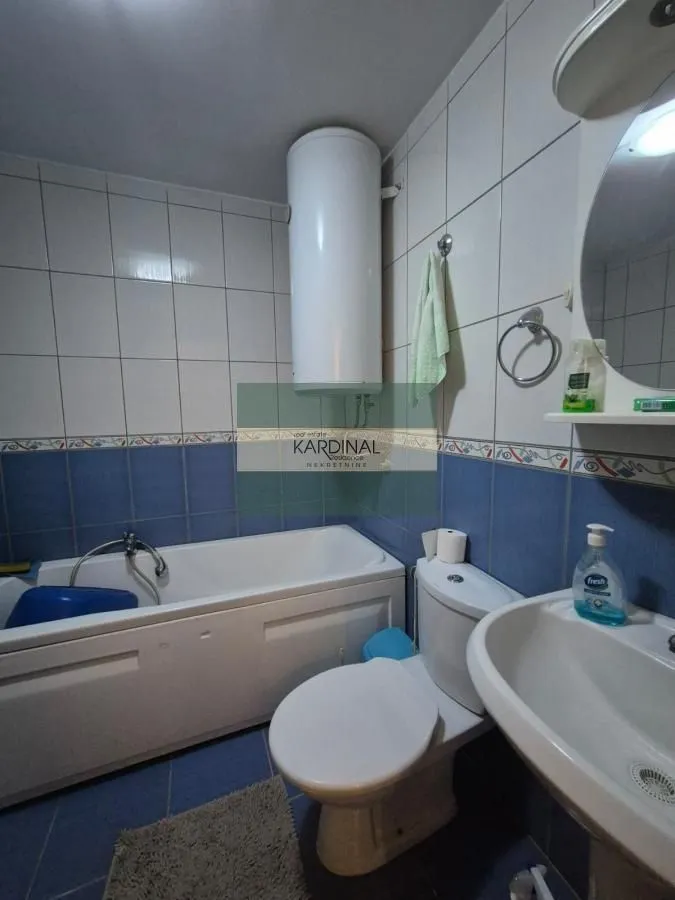 Manje kupatilo opremljeno kadom, umivaonikom i wc šoljom.