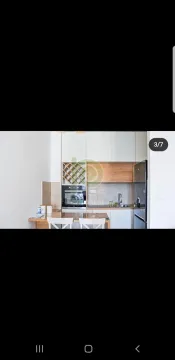 A bright kitchen featuring modern cabinets and a small dining counter. - image 3