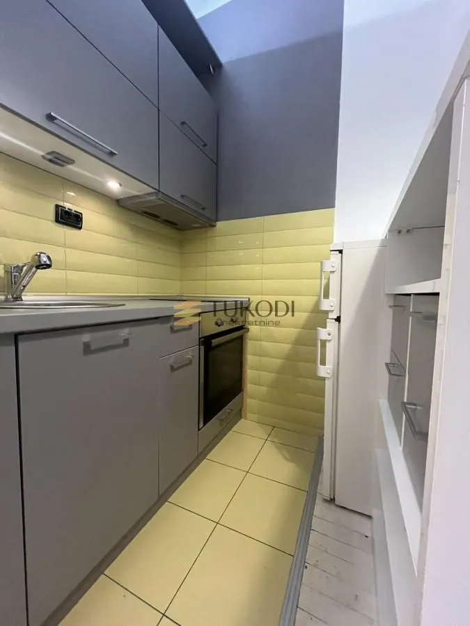 Small kitchen with grey cabinets and a built-in oven.