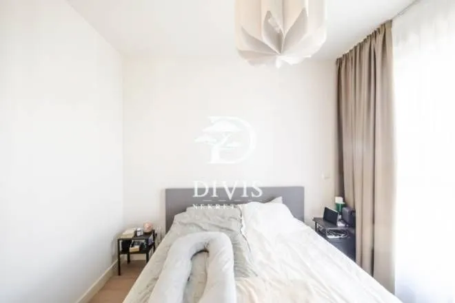 Bedroom with a double bed and a window with curtains.