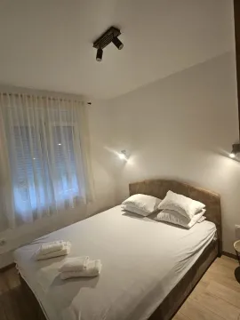Spavaća soba sa bračnim krevetom, prozorom i rasvjetom. - image 2