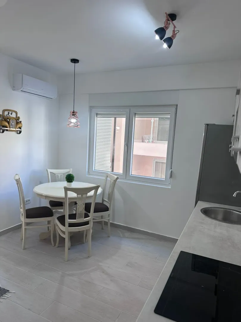Modern kitchen with a dining table and white chairs.