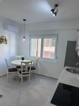 Modern kitchen with a dining table and white chairs. - image 4