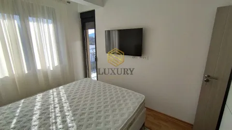 Bedroom with a bed and a wall-mounted TV. - image 11