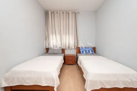 Bedroom with two single beds and a nightstand. - image 6