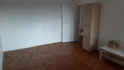 Prazna soba sa parketom na podu i belim zidovima. - image 4