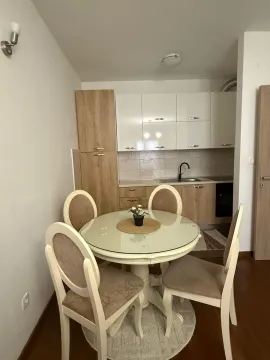 A dining table with chairs in front of a kitchen with light-colored cabinets. - image 6
