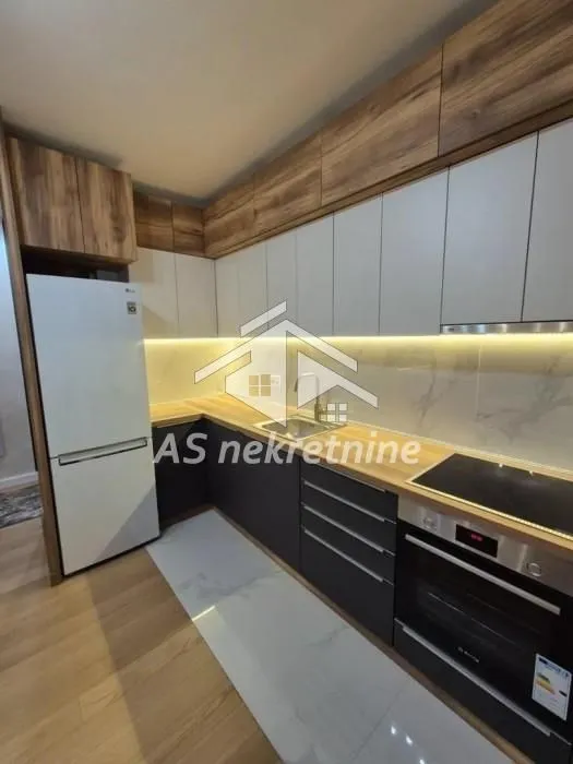 Modern kitchen with built-in appliances and a refrigerator.