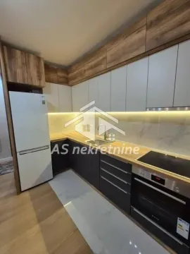 Modern kitchen with built-in appliances and a refrigerator. - image 10