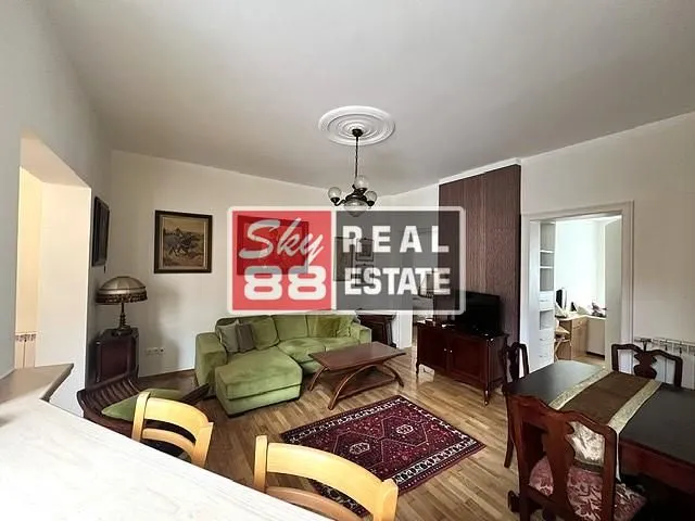 Dnevna soba sa garniturom, trpezarijskim stolom i parketom.