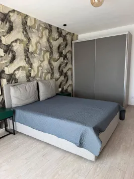 Furnished bedroom with a double bed, wardrobe, and patterned wall wallpaper. - image 4