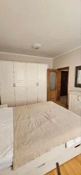 Spavaća soba sa velikim bračnim krevetom, bijelim garderoberom i vratima koja vode u hodnik. - image 6