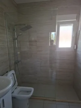 Moderno kupatilo sa staklenom tuš kabinom i keramičkim pločicama. - image 11