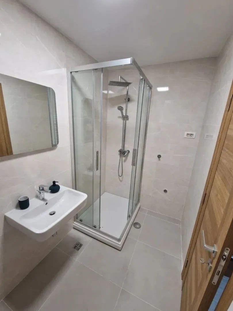 Modernly equipped bathroom with a shower cabin and a sink.
