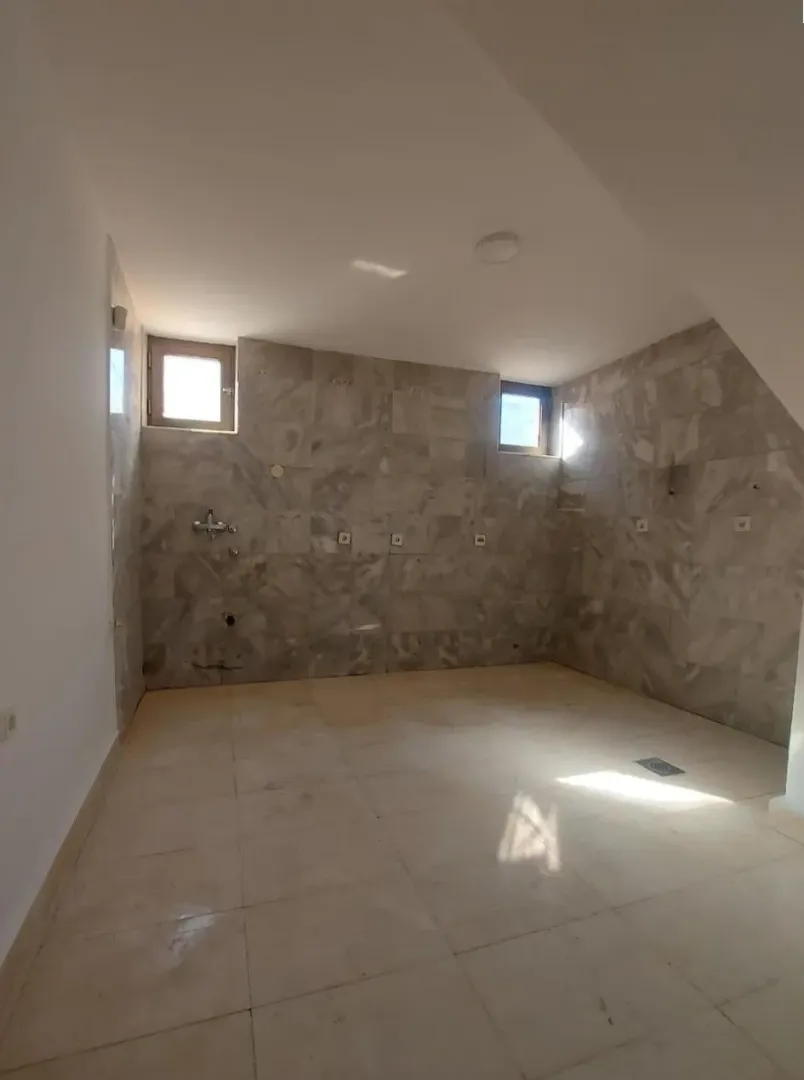 Empty bathroom with ceramic tiles and windows.